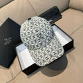 Chanel cap with white base and black repeating logo pattern, curved brim