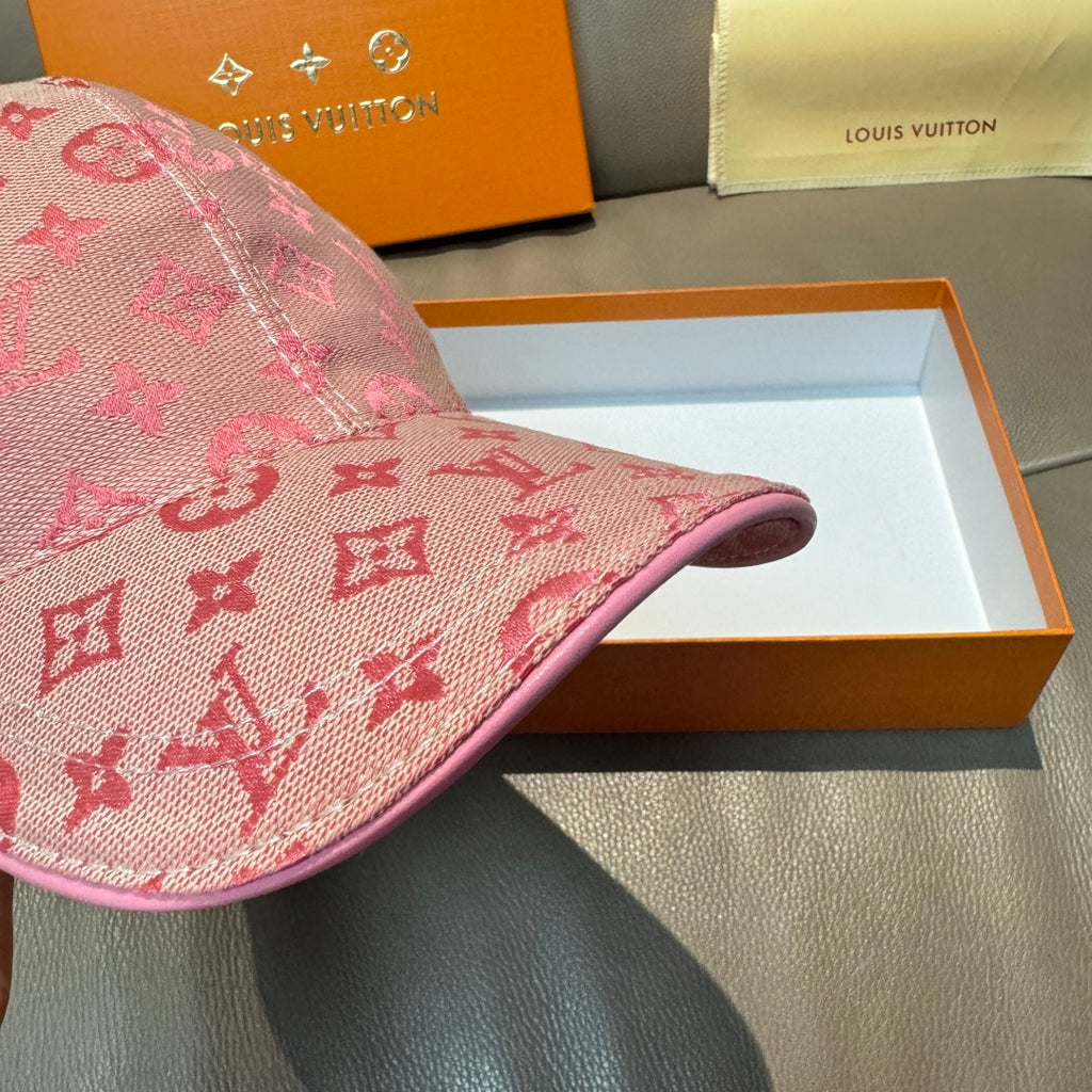 Louis Vuitton pink monogram cap close-up of side panel and curved brim edge.