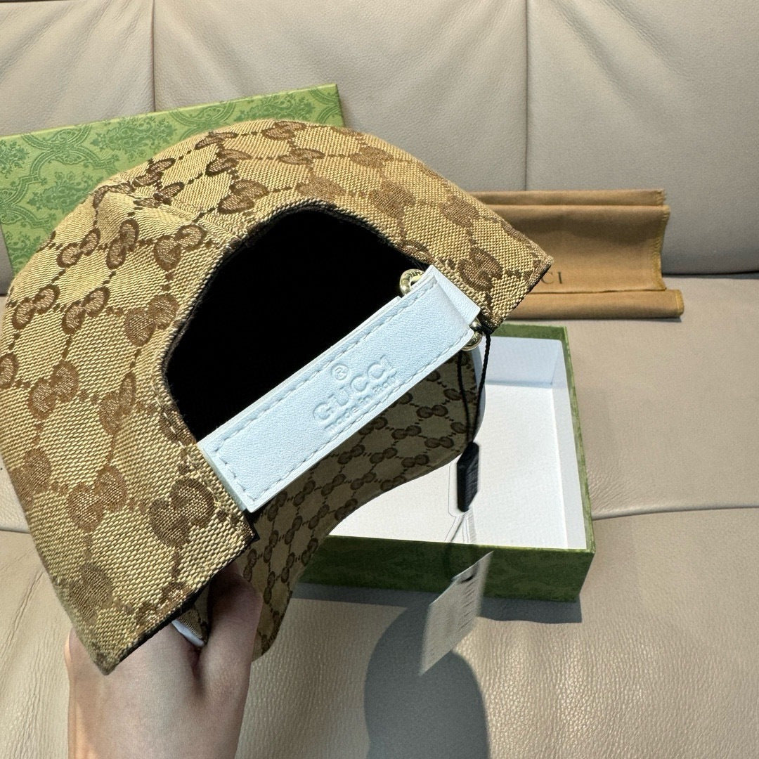 Beige GG-pattern baseball cap underside with black tie cord and light label.