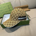 Beige GG-pattern baseball cap with black front patch reading GUCCI.
