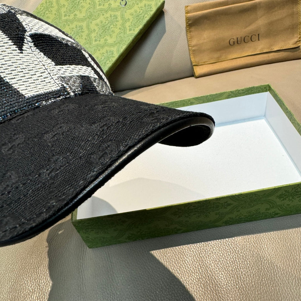 Black Gucci baseball cap brim close-up with textured black fabric edge.
