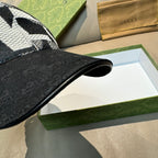 Black Gucci baseball cap brim close-up with textured black fabric edge.