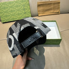 Black Gucci baseball cap with black-and-white monogram jacquard crown and logo strap.
