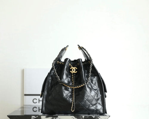 Black Chanel bag with quilted leather, chain handles, and gold CC logo at top