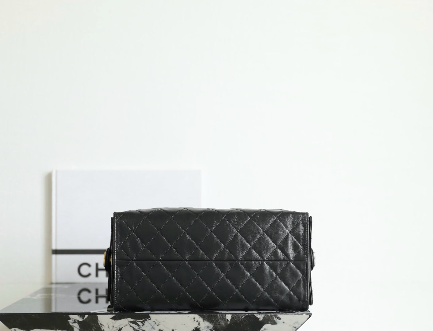 Black quilted Chanel bag with flap front and structured rectangular shape