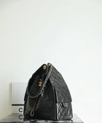 Black Chanel bag with quilted leather, short handles, and side zip pocket