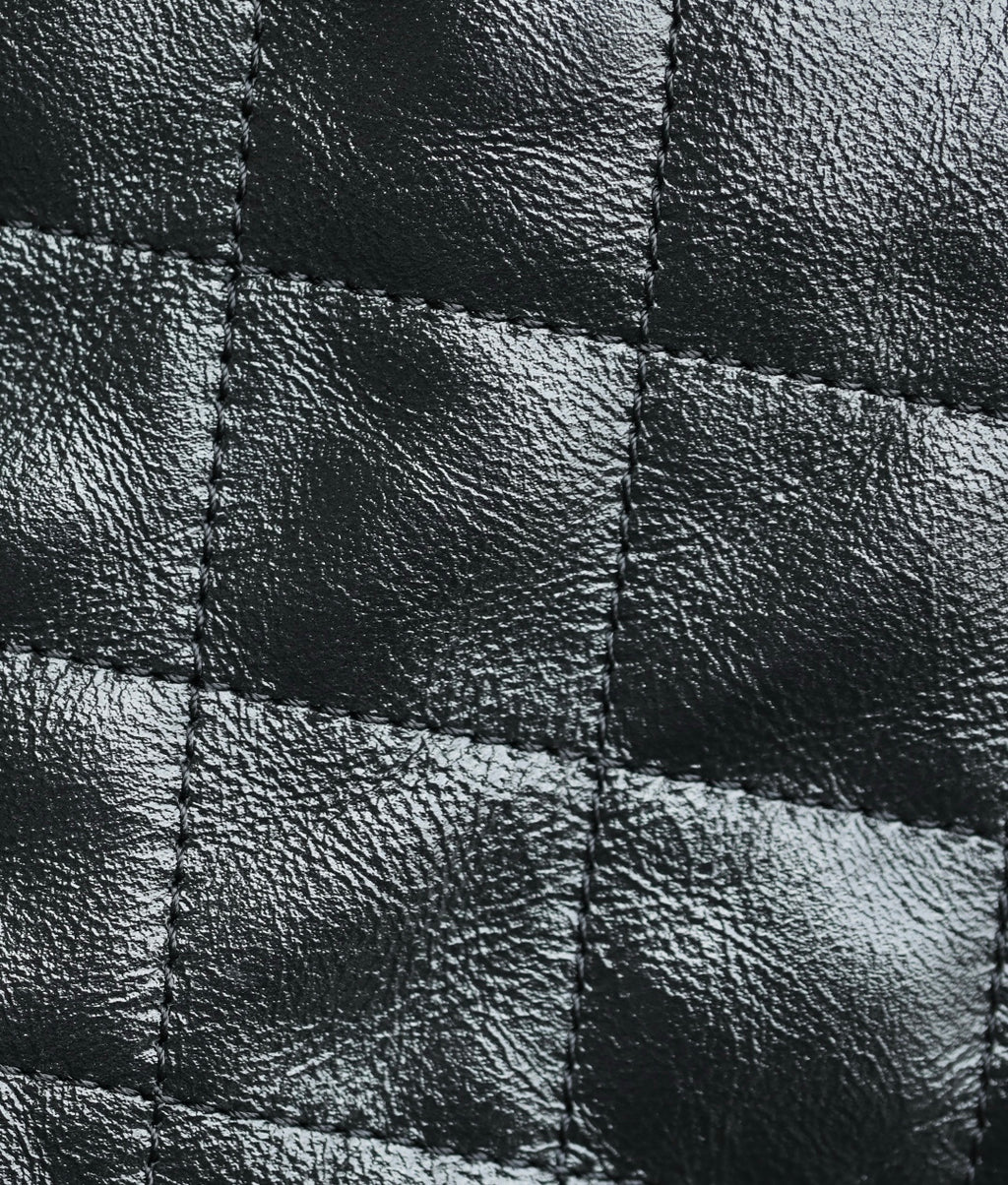 Black quilted leather close-up with stitched diamond panels