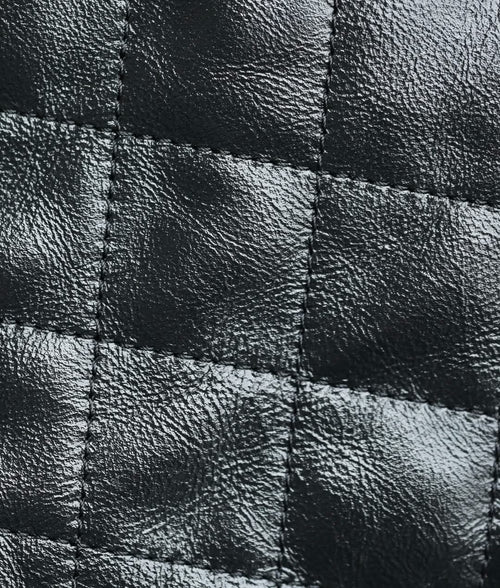 Black quilted leather close-up with stitched diamond panels