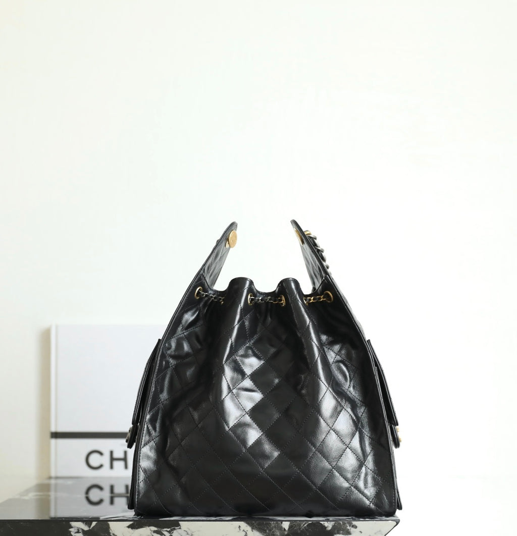 Black Chanel bag with quilted leather diamonds and braided chain top handles