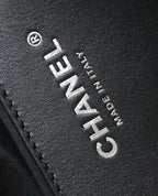 Black leather close-up with Chanel logo lettering and stitched trim
