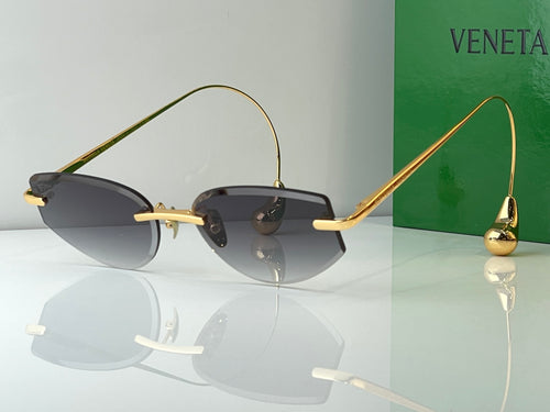Bottega Veneta glasses with gold metal frames and dark tinted lenses