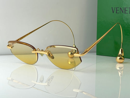 Glasses with gold metal frames and amber-yellow tinted lenses
