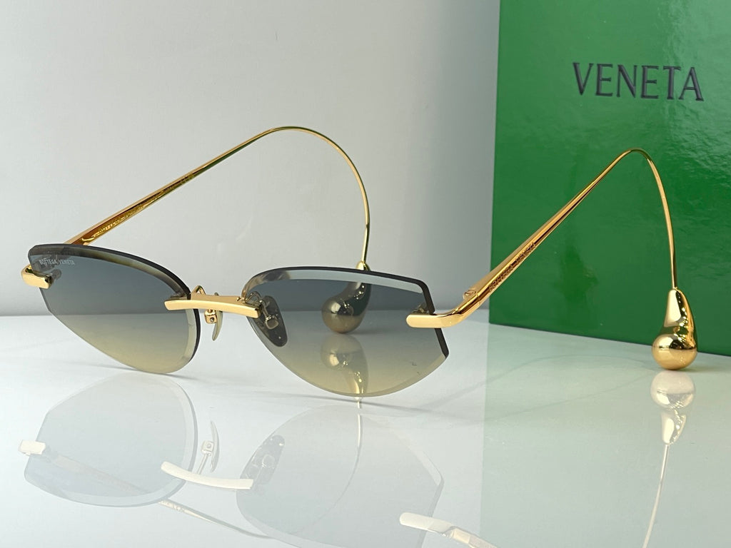 Glasses with gold metal frames and dark gray tinted lenses