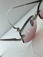Metal glasses with dark rim, gold accents, and pink-tinted lens