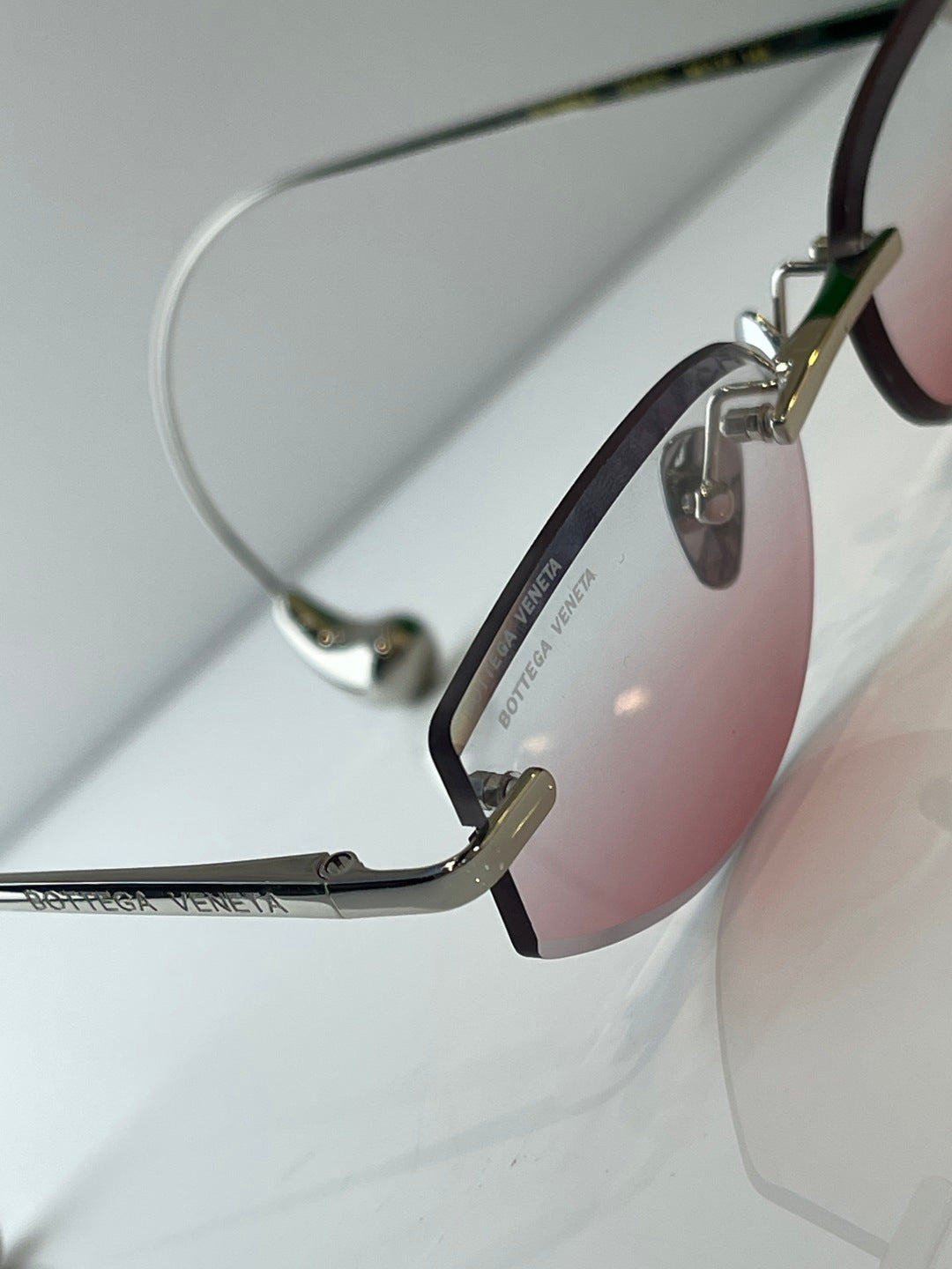 Metal glasses with dark rim, gold accents, and pink-tinted lens