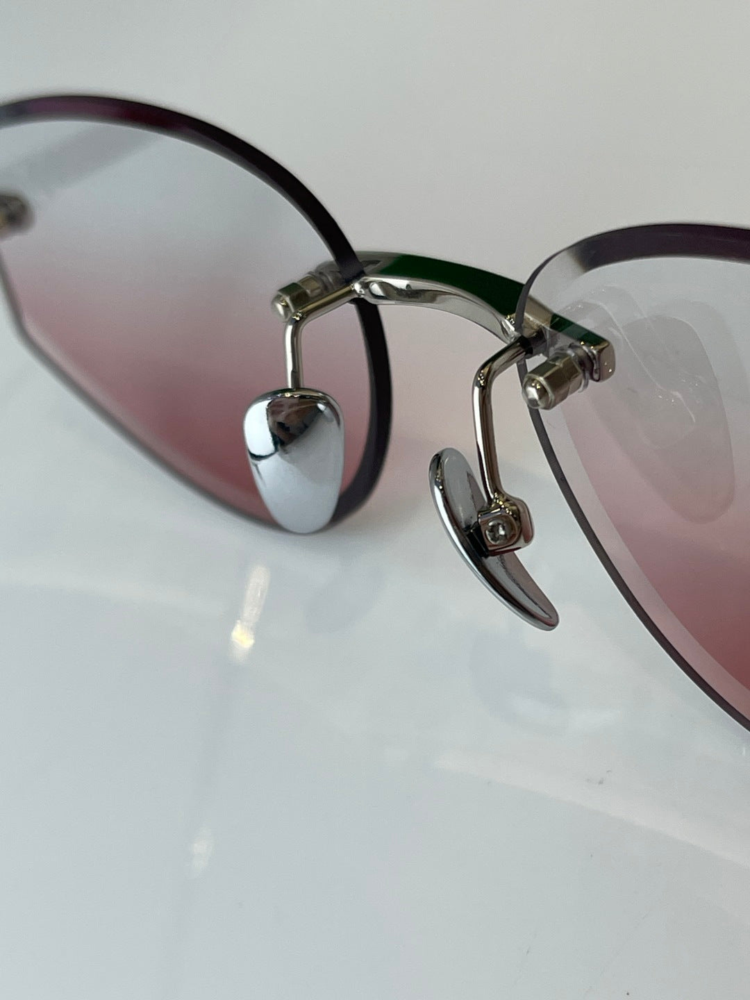 Glasses with black rims, gold hinges, and pink tinted lenses