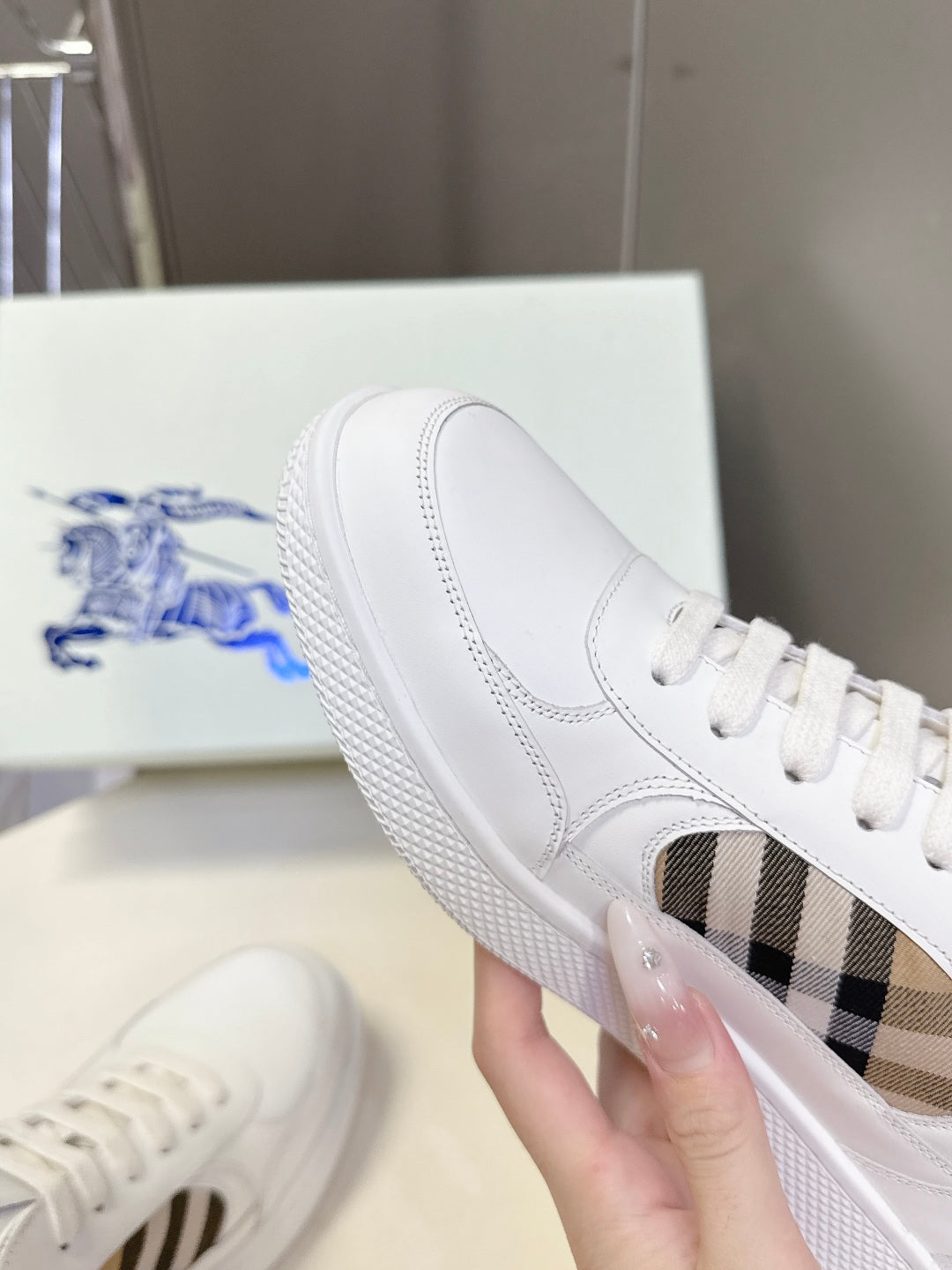 White low-top sneakers with blue horse logo tongue and check-pattern side detail