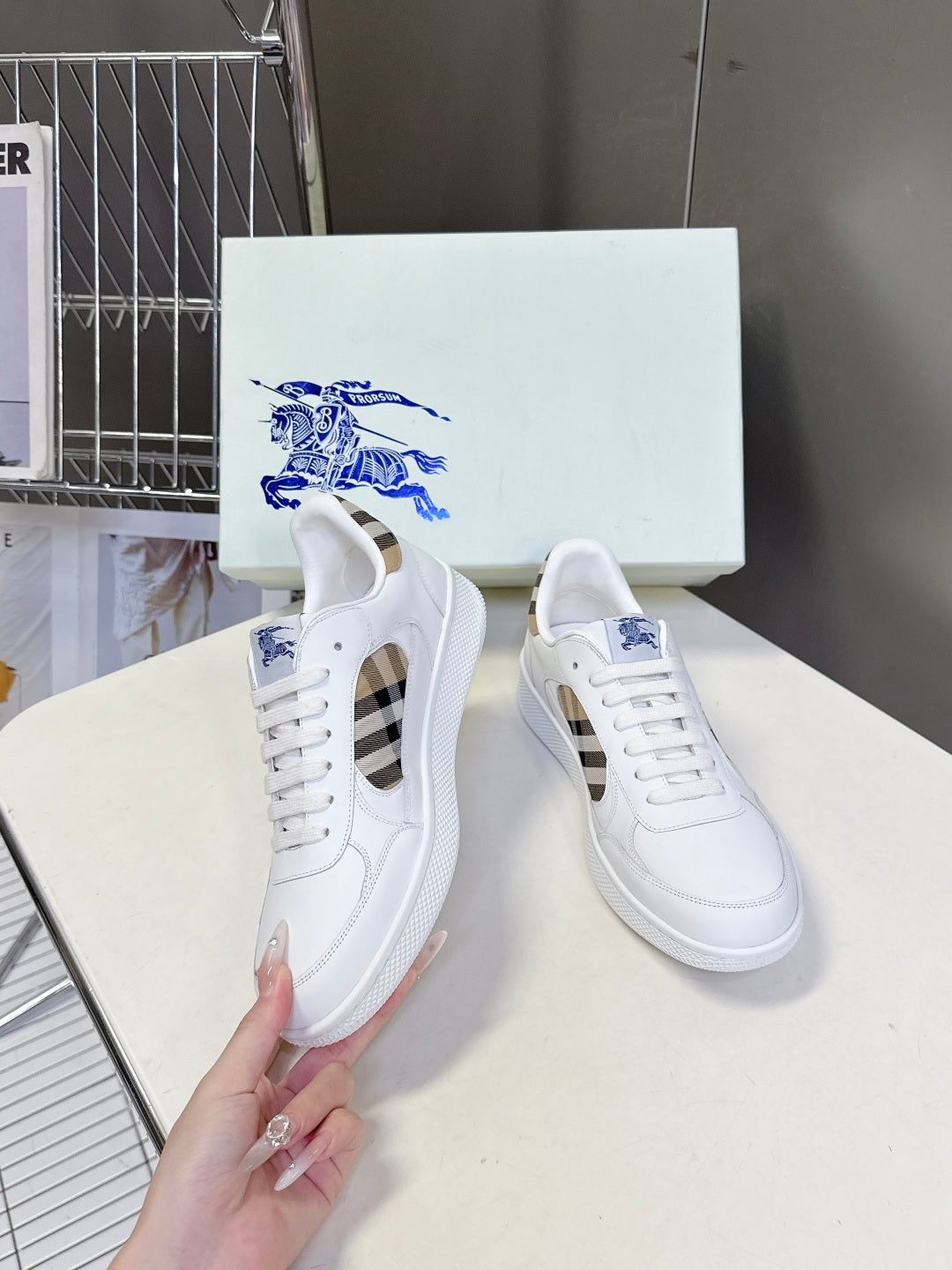 White low-top sneakers with blue horse logo, perforated details, and check-pattern sides