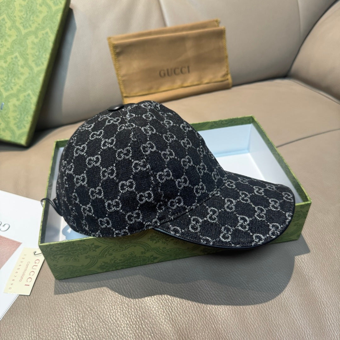 Black GG-style monogram baseball cap lying in a box with adjustable button detail.