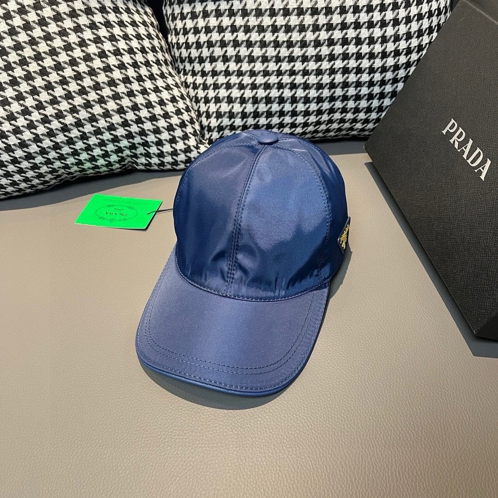 Prada blue baseball cap with curved brim, side stitching, and green hang tag.