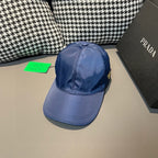 Prada blue baseball cap with curved brim, side stitching, and green hang tag.