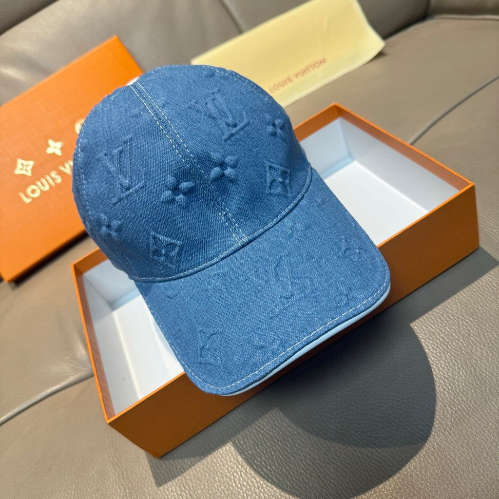 Blue denim cap with embossed monogram pattern, curved brim, stitched crown