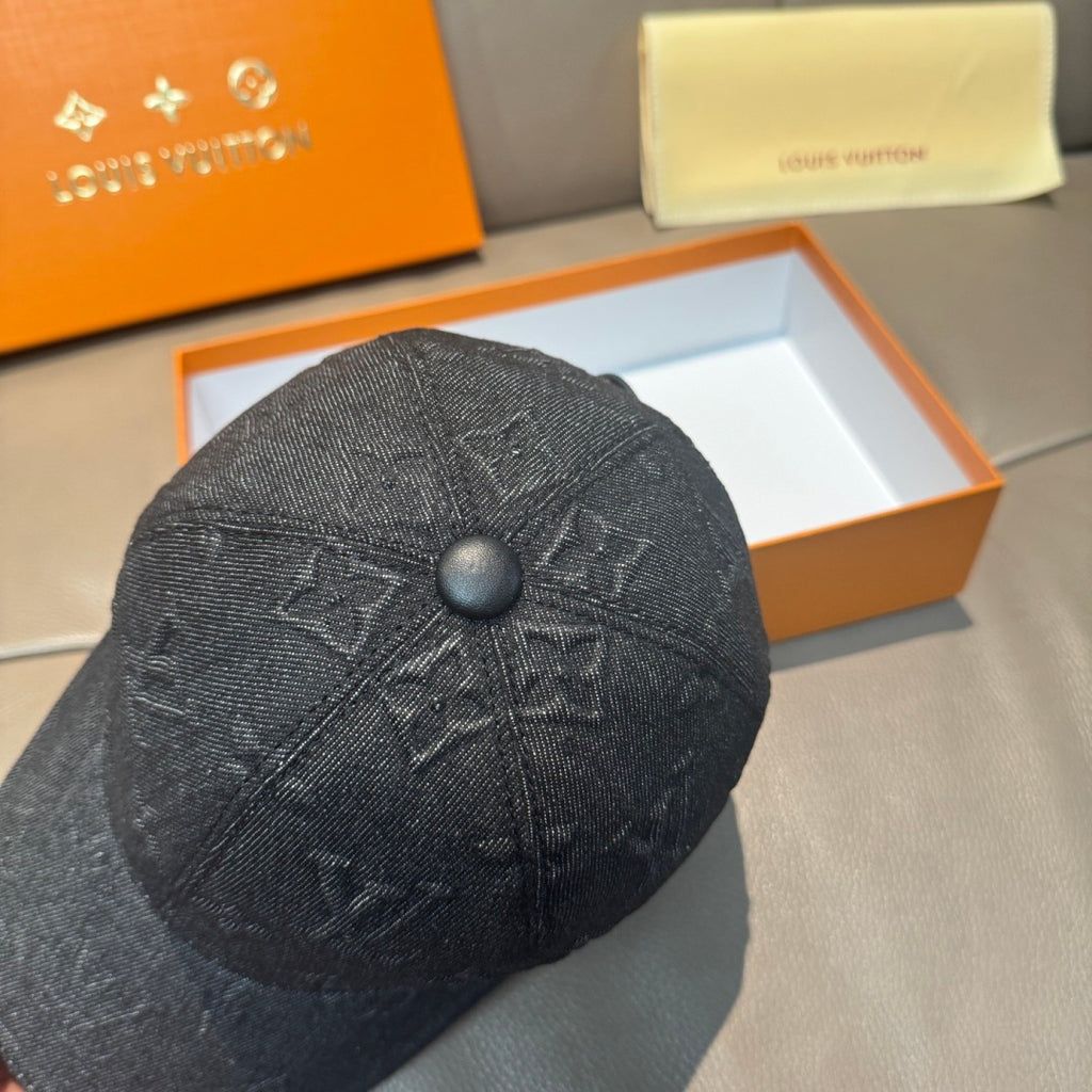 Black denim baseball cap close-up with embossed monogram pattern and round top button