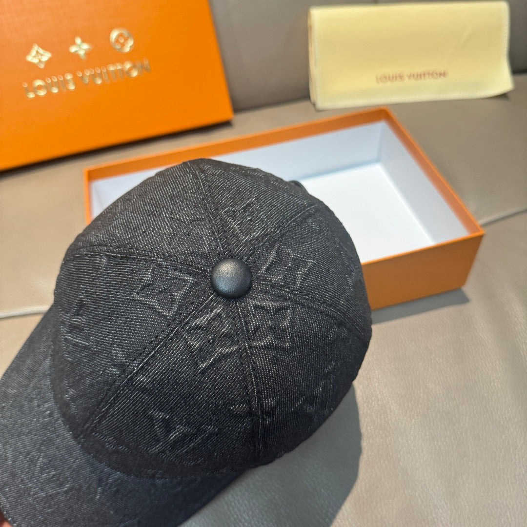 Black denim baseball cap close-up with embossed monogram pattern and round top button