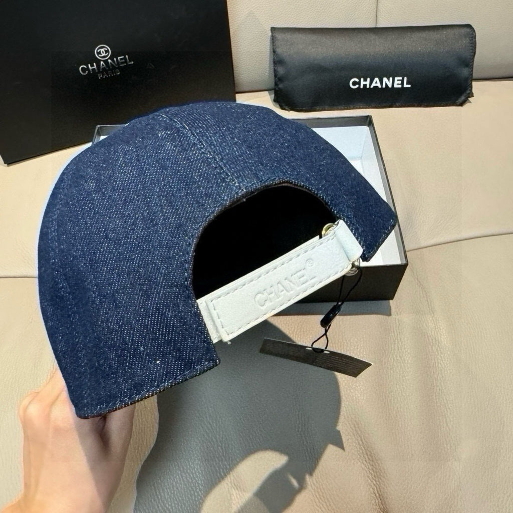 Denim baseball cap with white interior band and hanging Chanel tags.