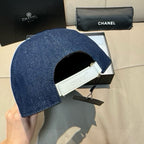 Denim baseball cap with white interior band and hanging Chanel tags.