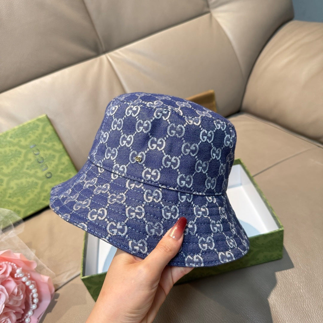 Gucci bucket hat in blue GG monogram denim, front view with hand