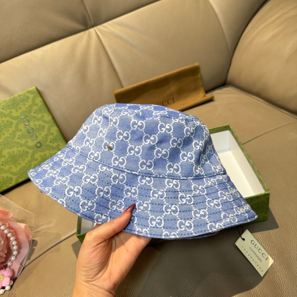 Gucci blue bucket hat with GG monogram pattern, held in hand