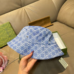 Gucci blue bucket hat with GG monogram pattern, held in hand