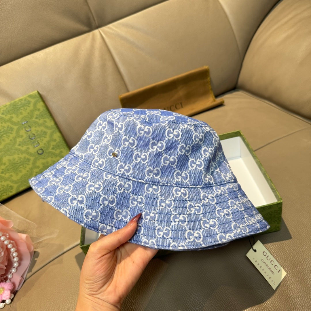 Gucci blue bucket hat with GG monogram pattern, held in hand
