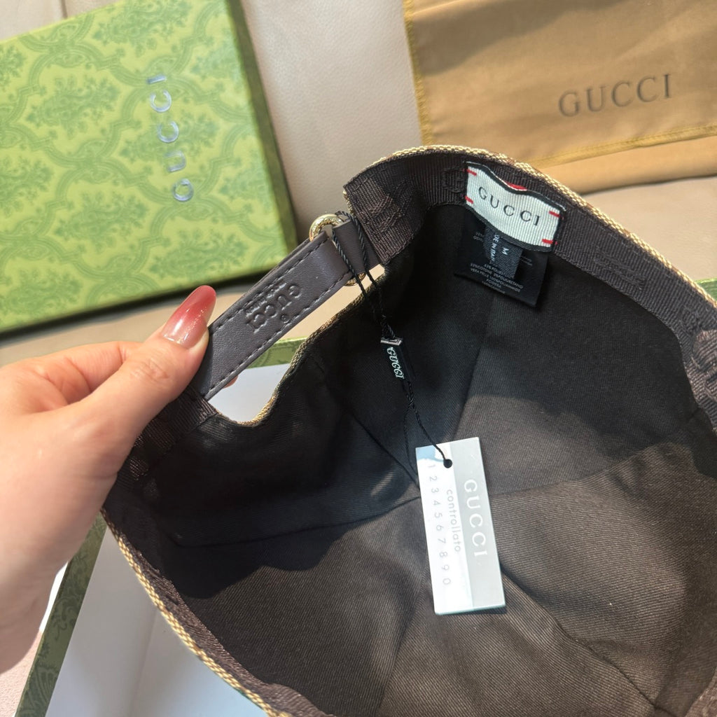 Gucci baseball cap interior view with black adjustable strap and hanging tag.