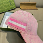 Gucci pink GG jacquard cap with wide pink-and-white striped web on the front.
