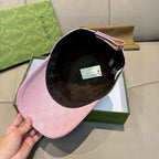 Gucci pink cap held open, showing black interior lining and adjustable strap.