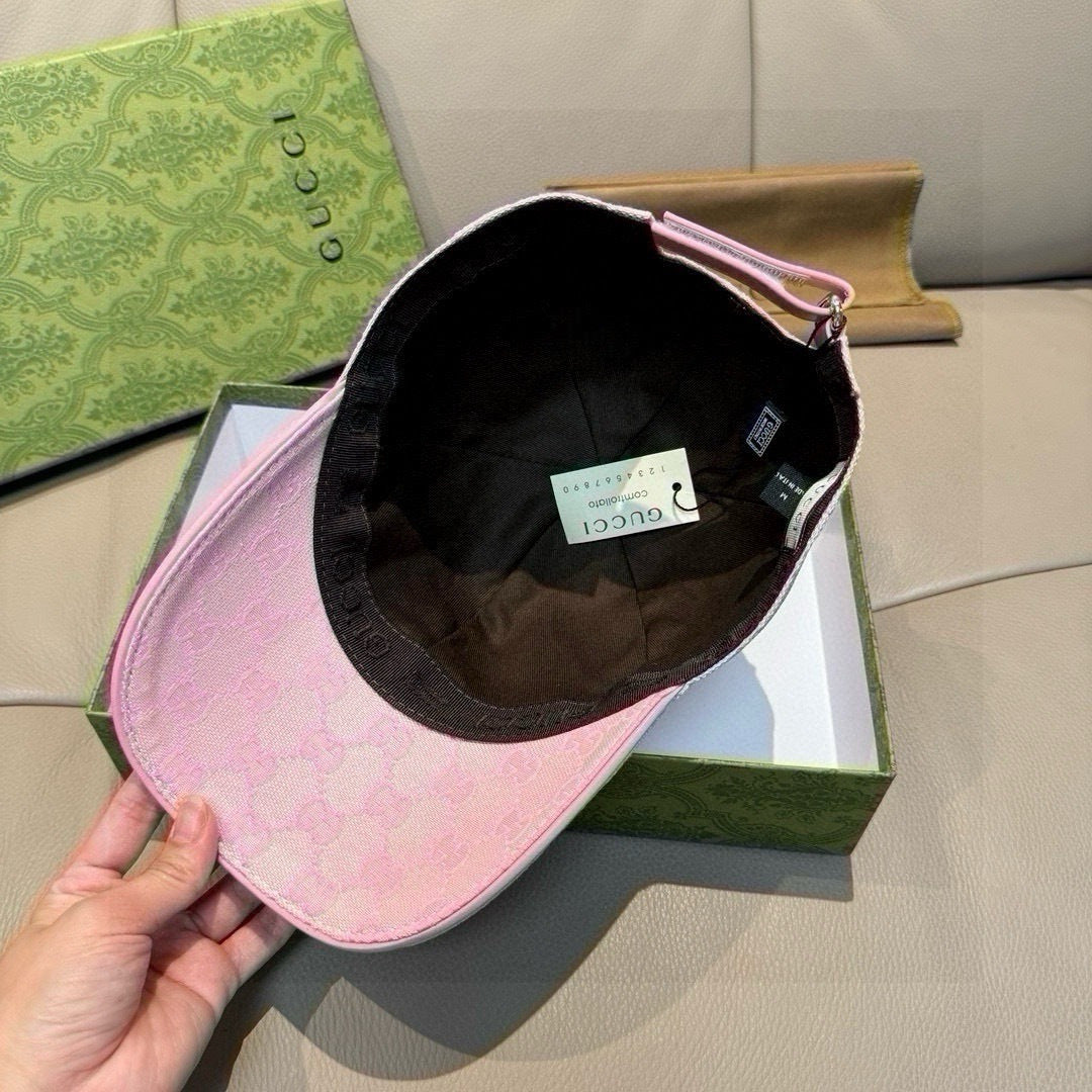 Gucci pink cap held open, showing black interior lining and adjustable strap.