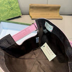 Gucci cap interior with black lining, pink edge, and hanging brand tags.