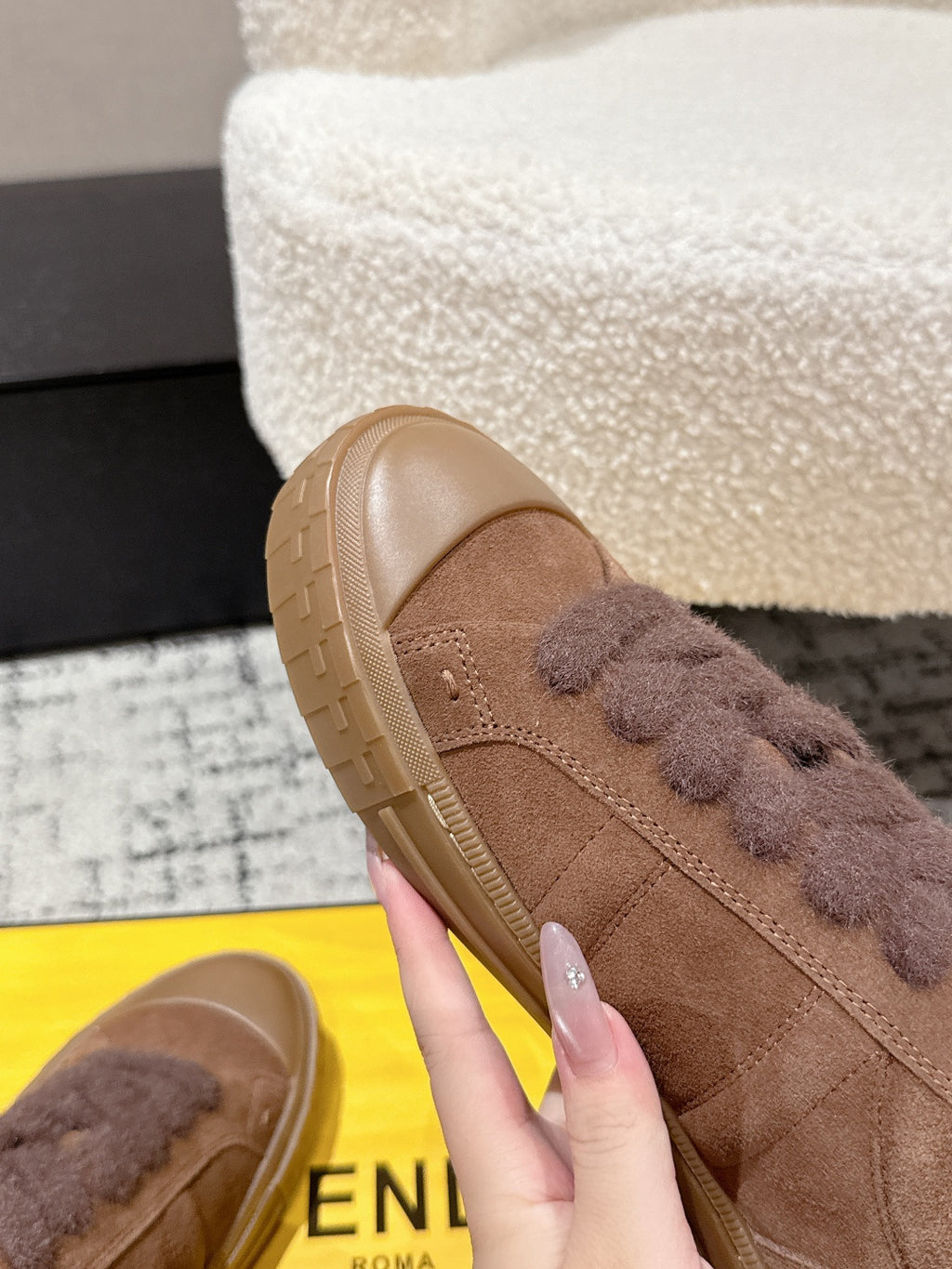 Brown suede Fendi sneaker toe close-up with lace trim and textured sole
