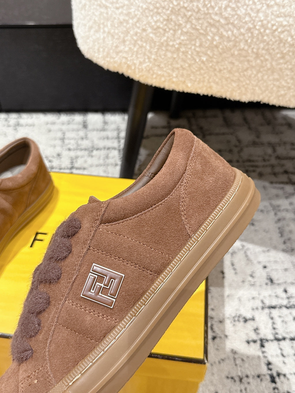 Brown suede Fendi sneakers close-up with side FF logo and lace trim