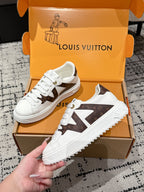 White low-top sneakers with brown star panel and textured rubber sole