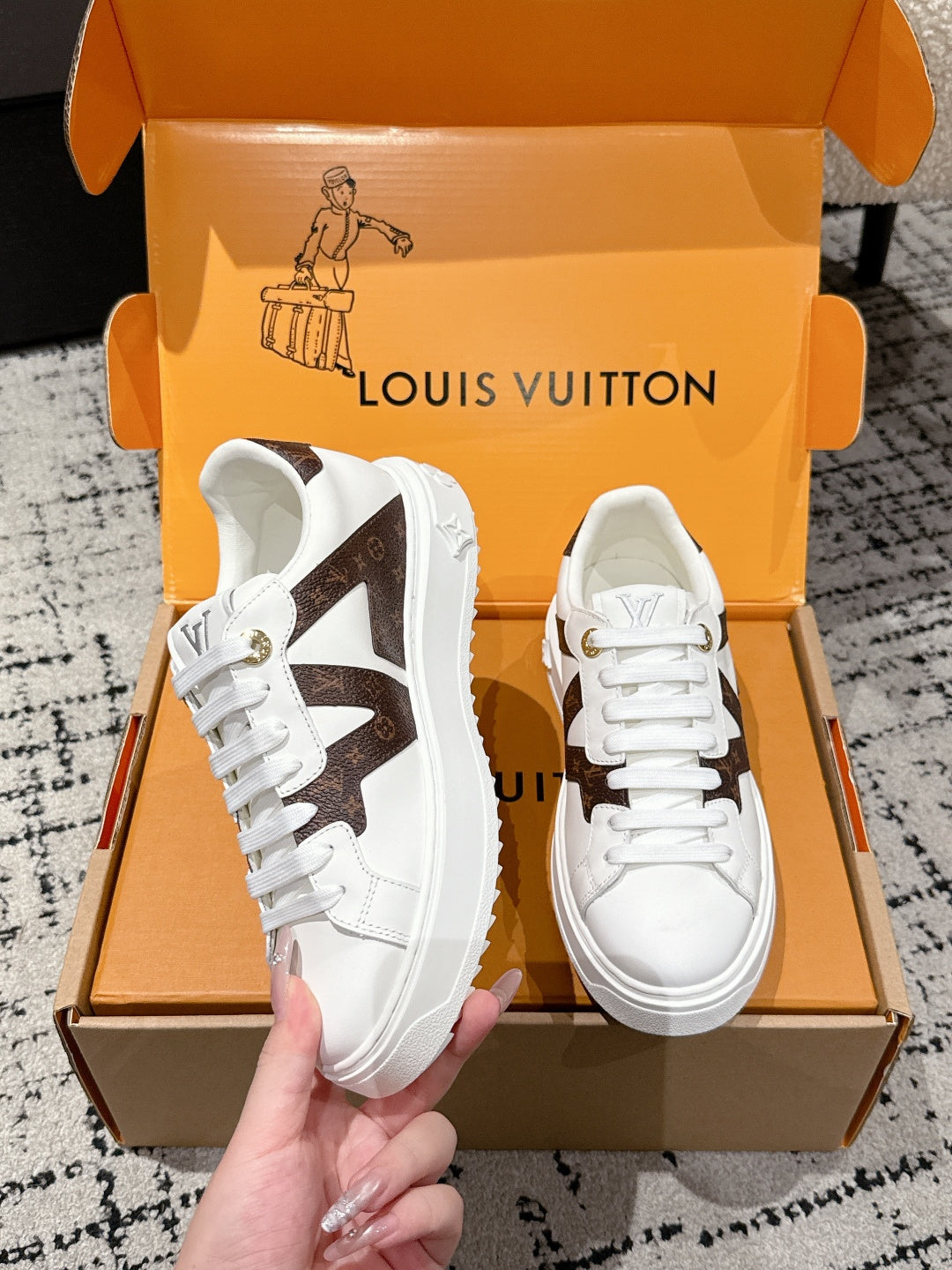 White low-top sneaker with brown monogram-style star panel and white lace-up