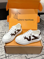 Pair of white low-top sneakers with brown star-like panels and white lace-up front