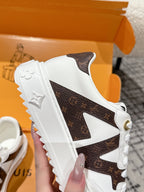 White sneaker with brown side panel, embossed sole edge, and lace-up front