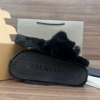 Black plush slide sandals with textured sole and Balenciaga embossed on footbed
