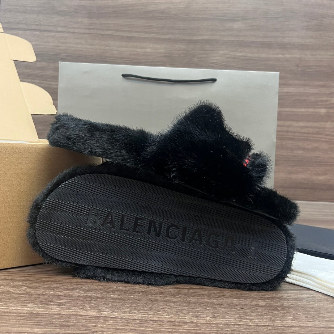 Black plush slide sandals with textured sole and Balenciaga embossed on footbed