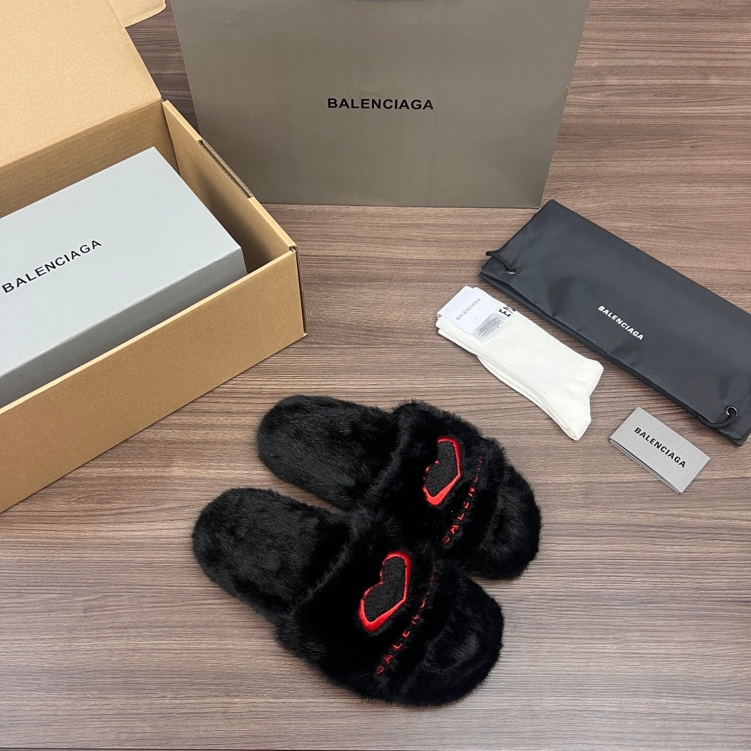 Black plush slide sandals with red logo outline, angled front view