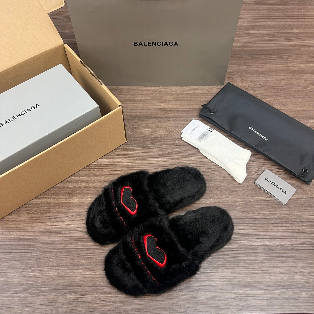 Black plush slide sandals with red logo outline, crossed straps