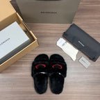 Black plush slide sandals with red logo outline, front view
